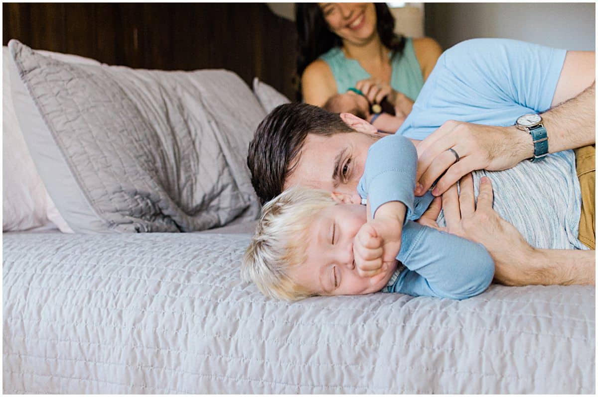 daddy and little boy laughing from tickle games while mom is smiling at them in Montclair NJ