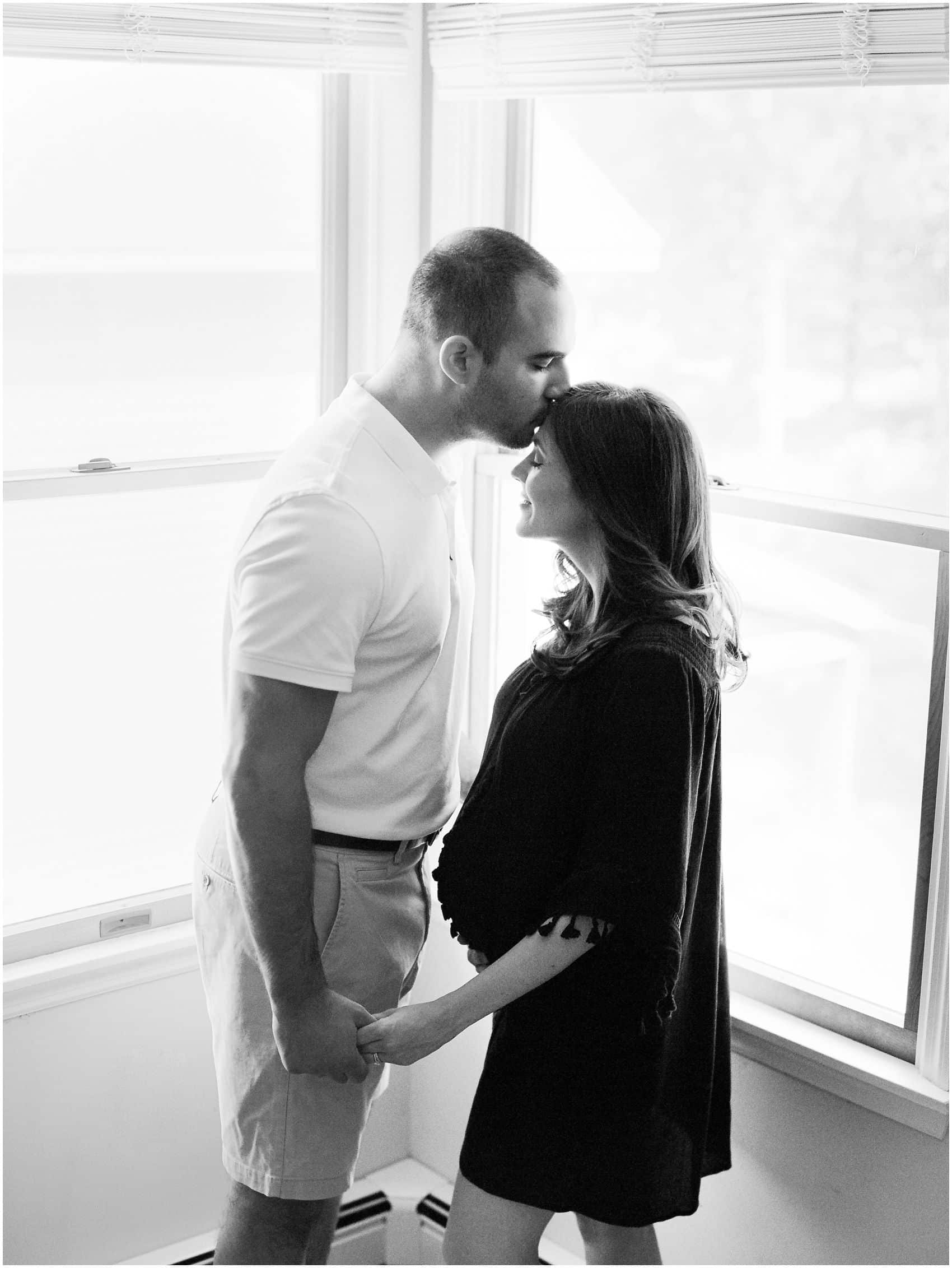 intimate black and white portrait of a pregnant couple at home during maternity photoshoot