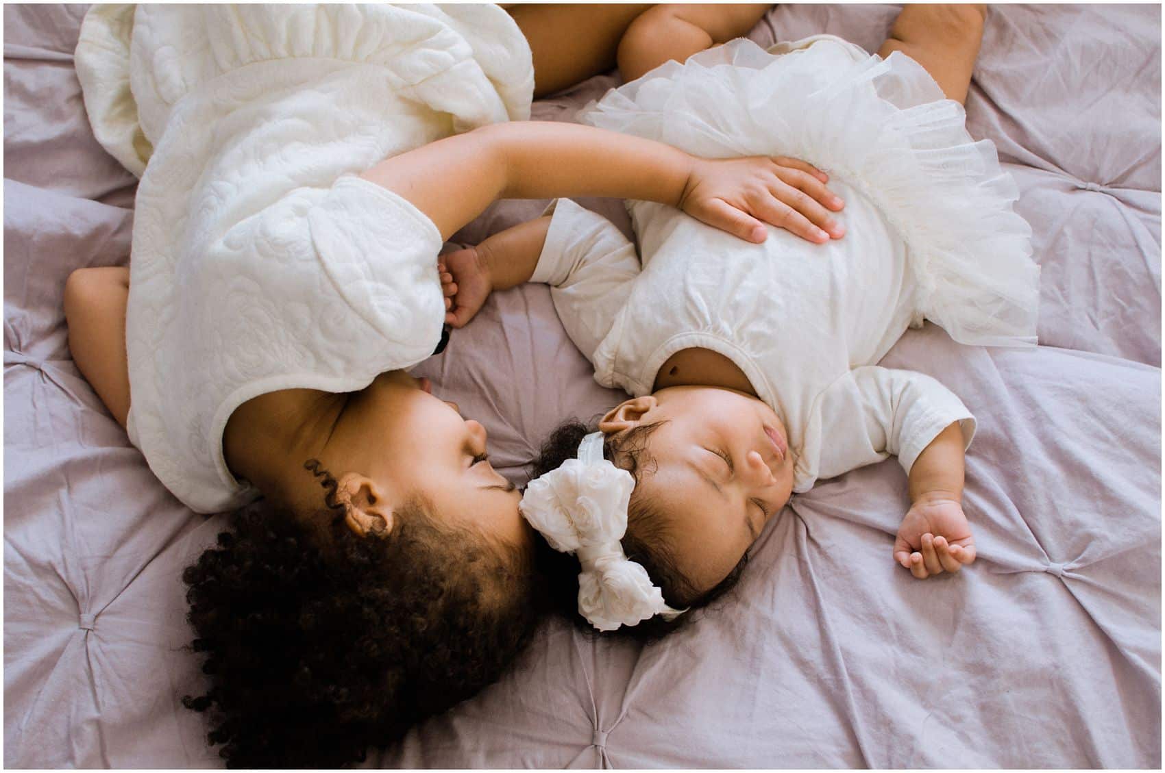 sweet newborn baby girl with her older sister sleeping in Manhattan NY