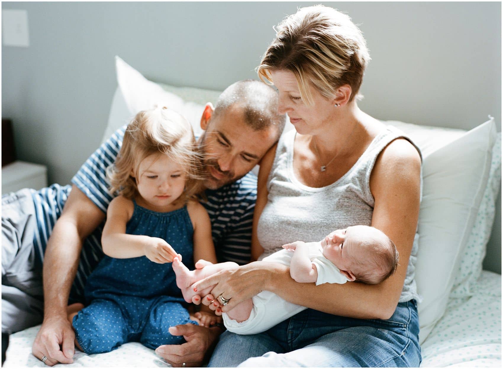 relaxed family portrait at home touching baby's toes