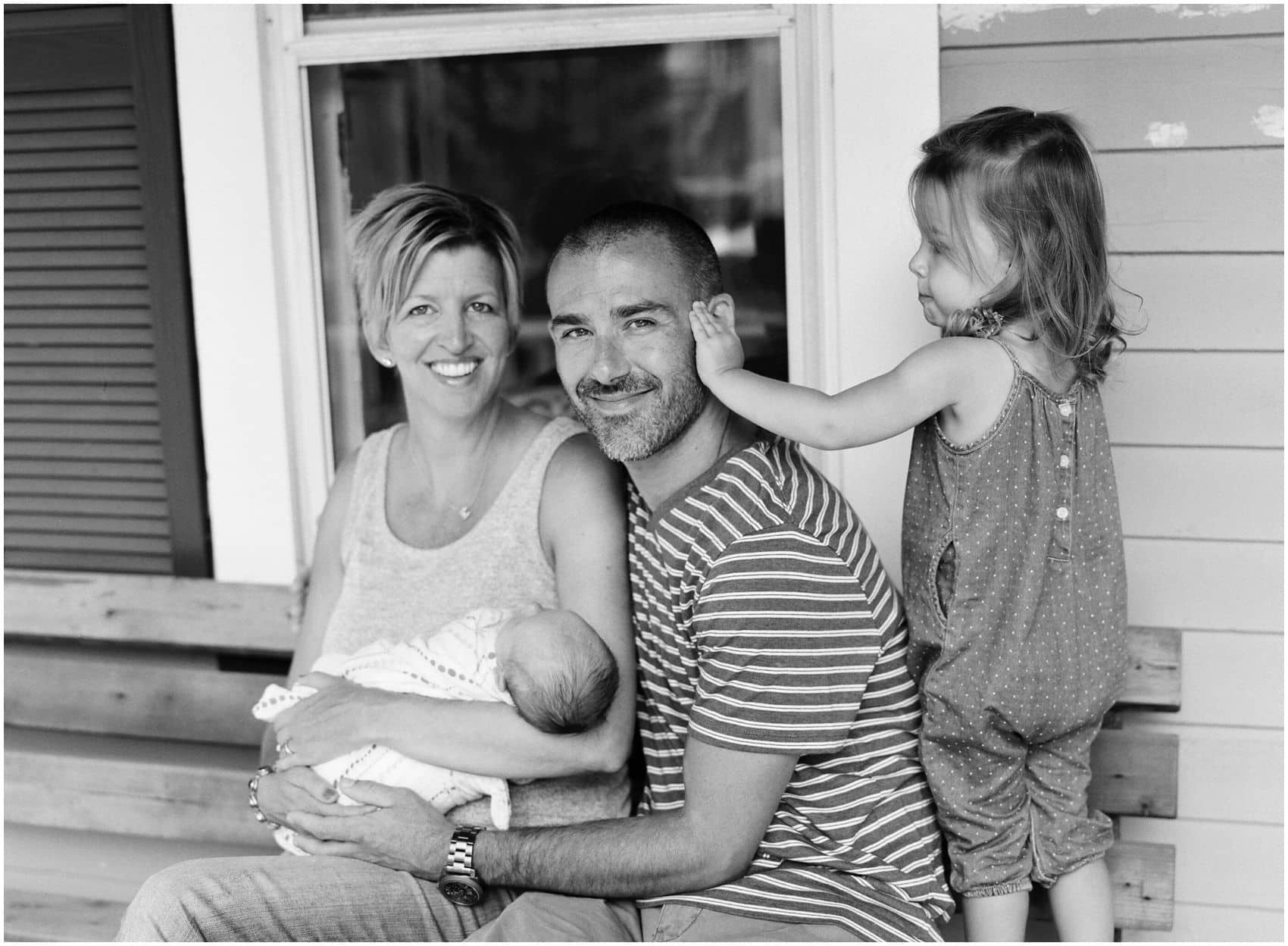 beautiful portrait of family outside their home with two kids
