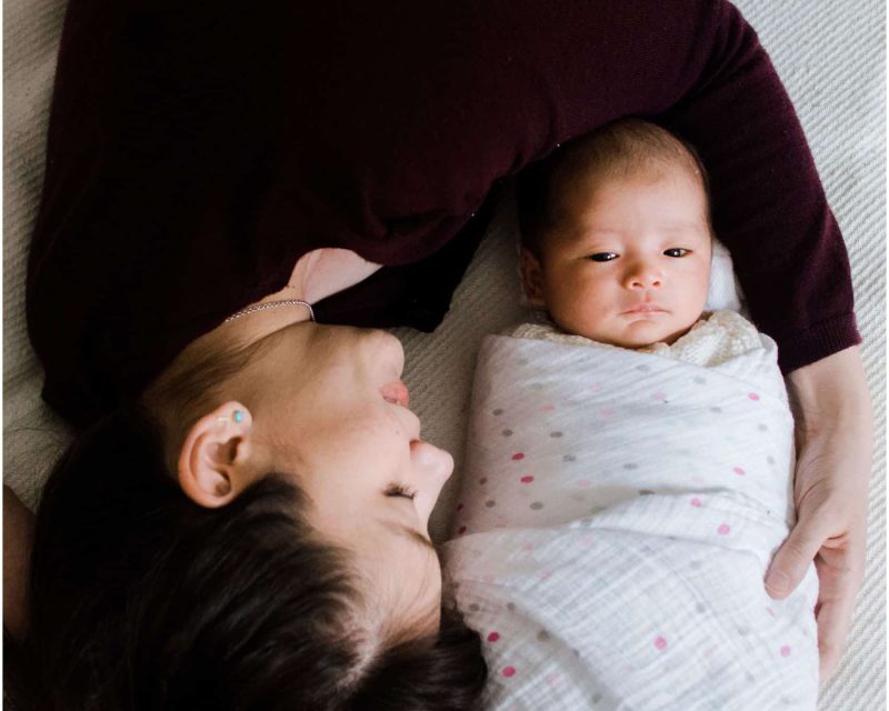 newborn photography NYC with mom cuddling around her baby