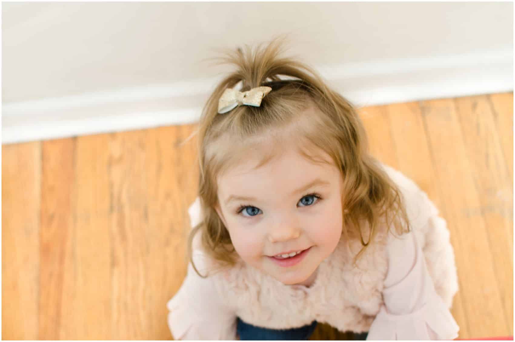little blonde girl with blue eyes looking up and smiling in NJ family photos of Mommy and Me Session
