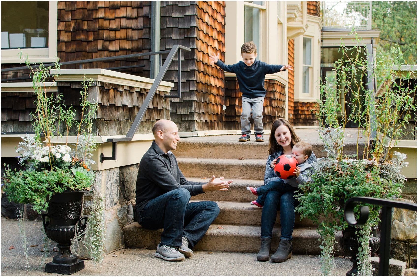 mom and dad play ball with their kids in the Reeves-Reed Arboretum NJ during family photos