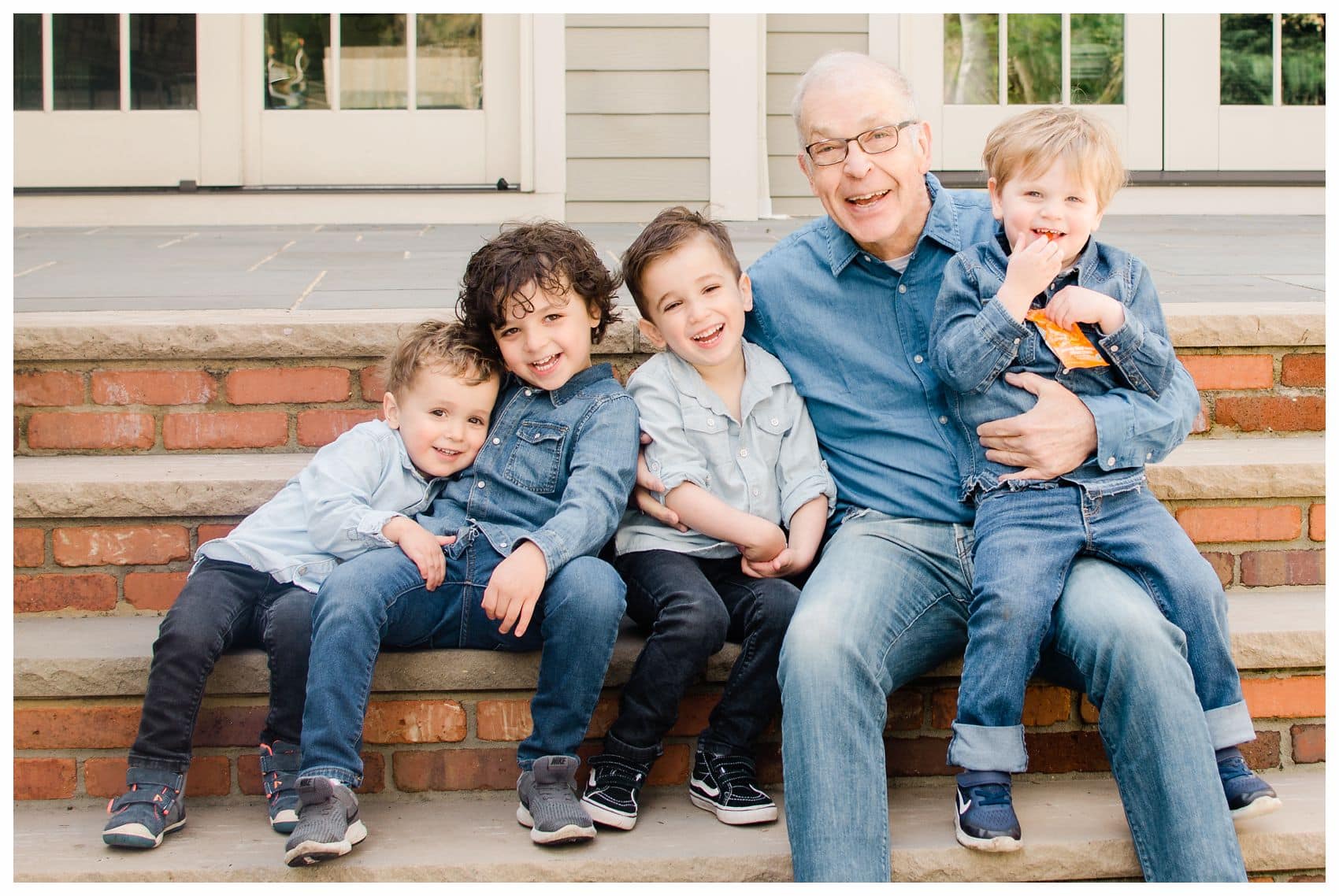 happy grandfather and grandkids hugging and laughing at the steps of their home in Essex County NJ