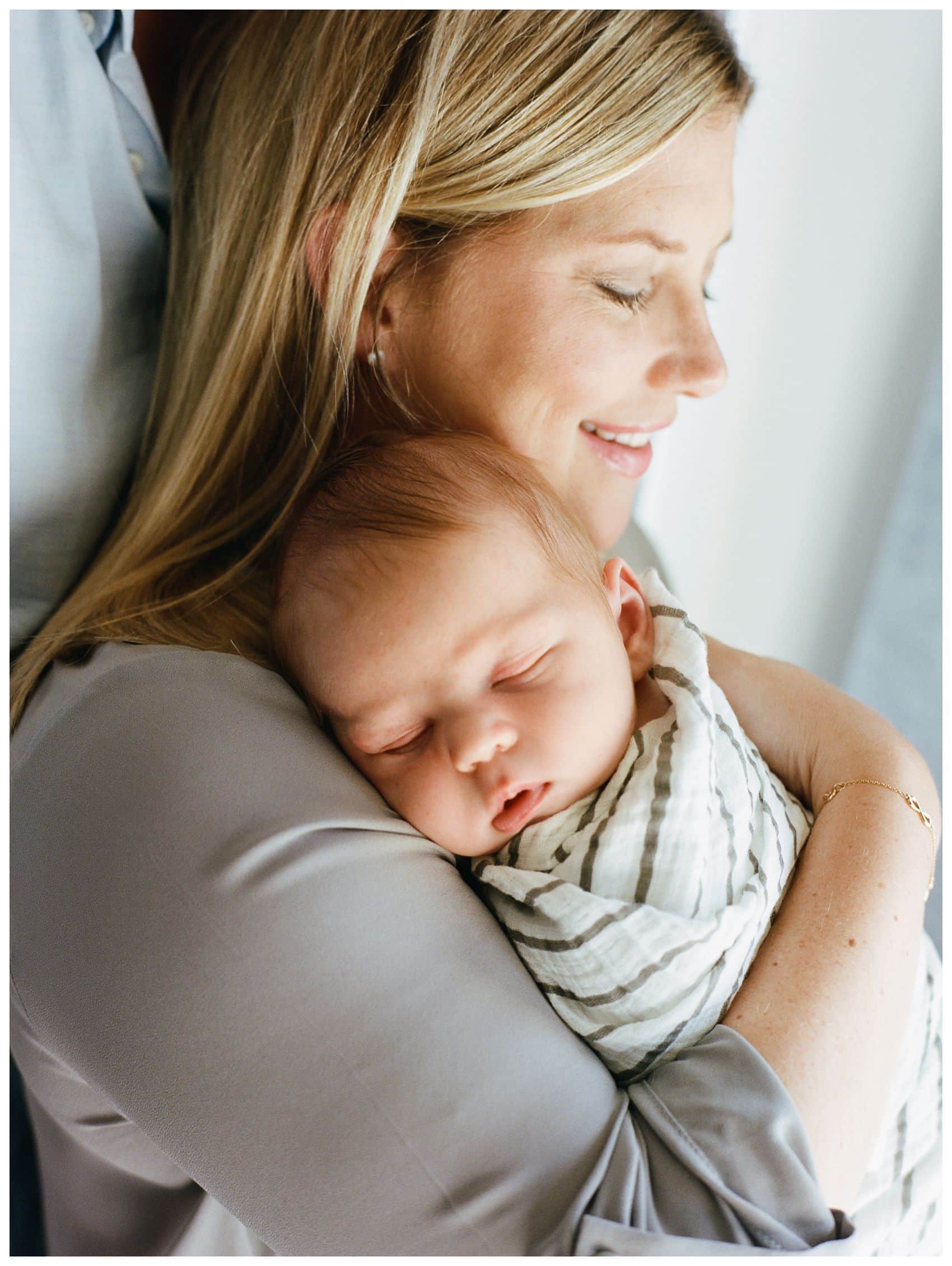 mom holding her newborn son in 7 tips on how to choose the best newborn photographer 