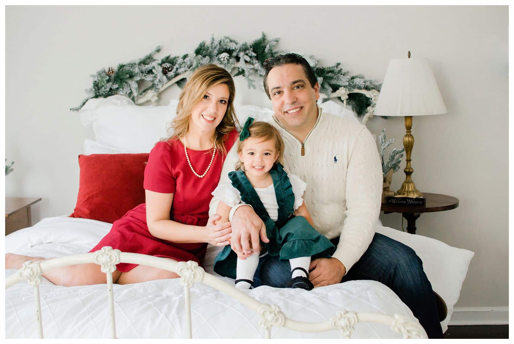family holiday photo shoot at NJ home on the bed with mom dad and little girl