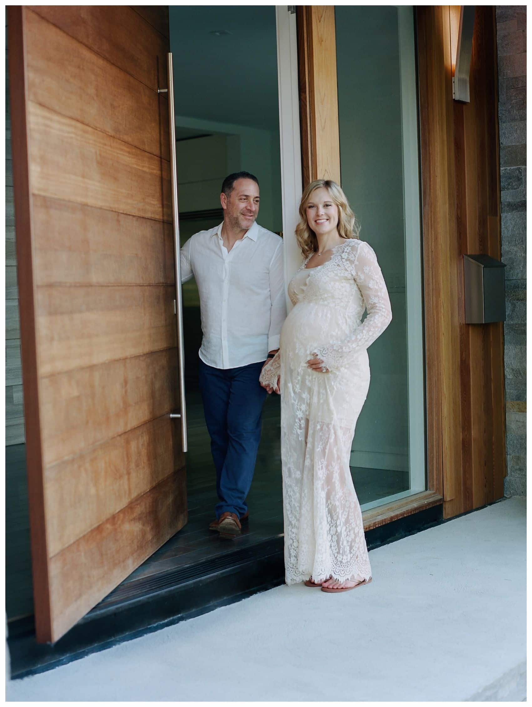 pregnant couple opening big wooden door to their home in Montclair NJ