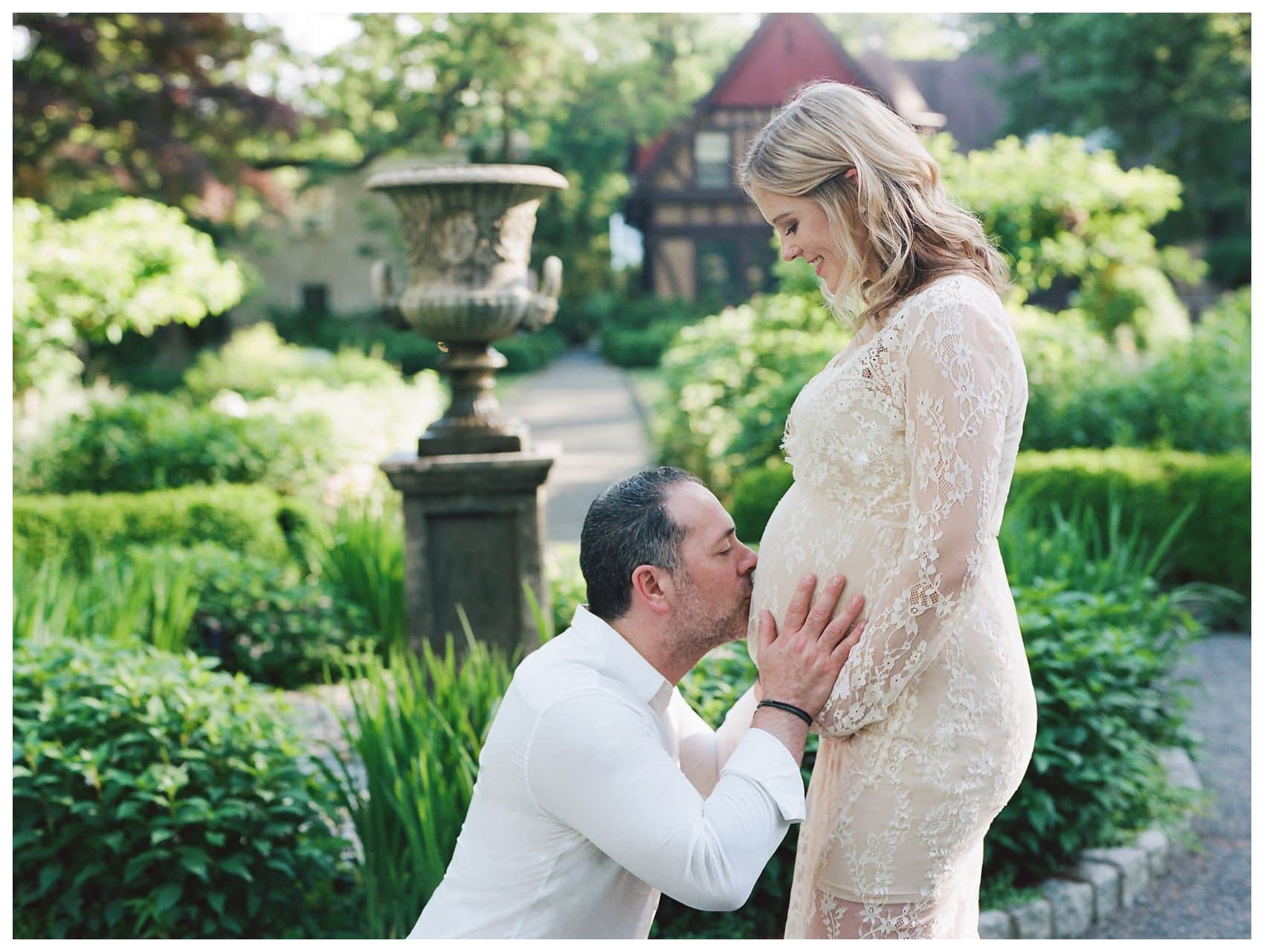 Husband kissing his wife pregnant belly for maternity session around 30 weeks in Montclair NJ Van Vleck House & Gardens
