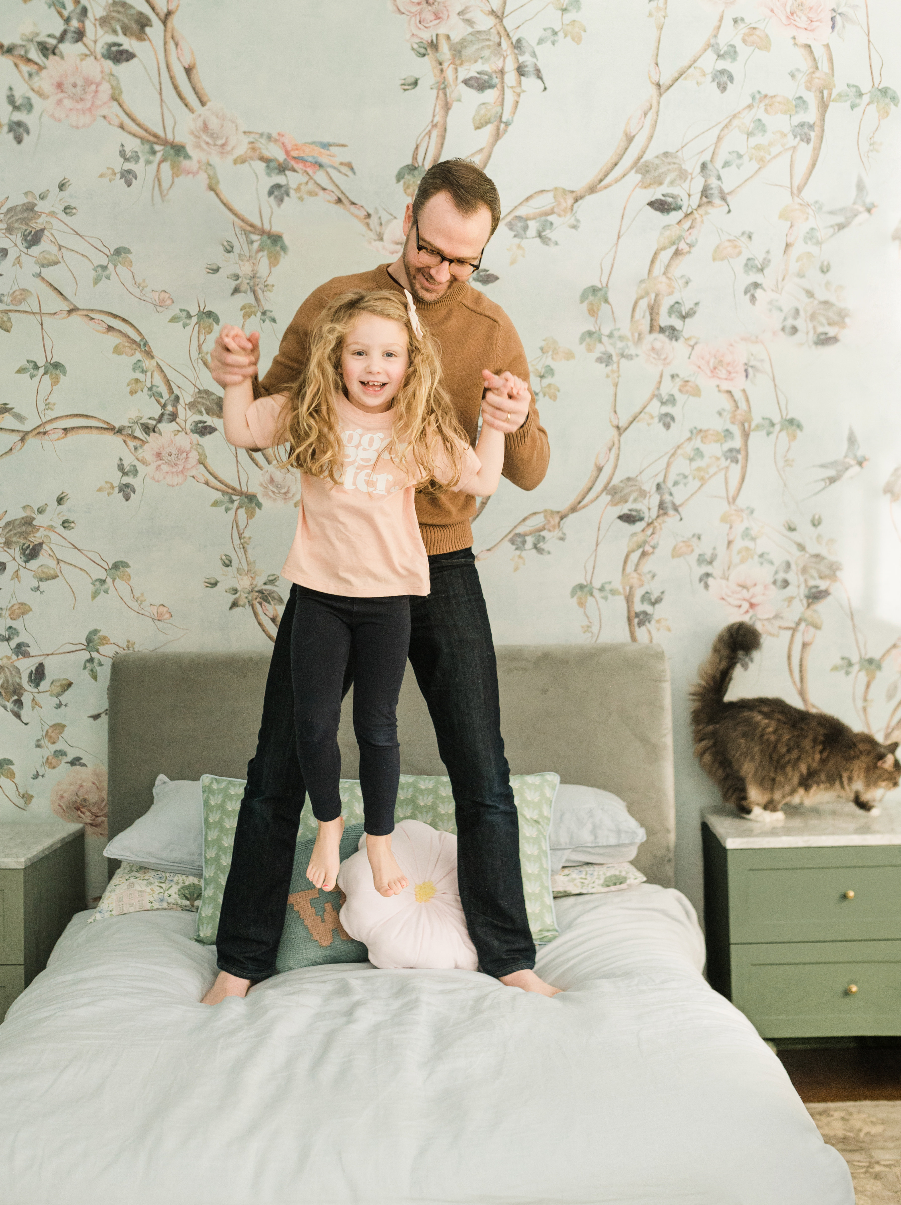 father and daughter jumping on a bed during NYC family photography session