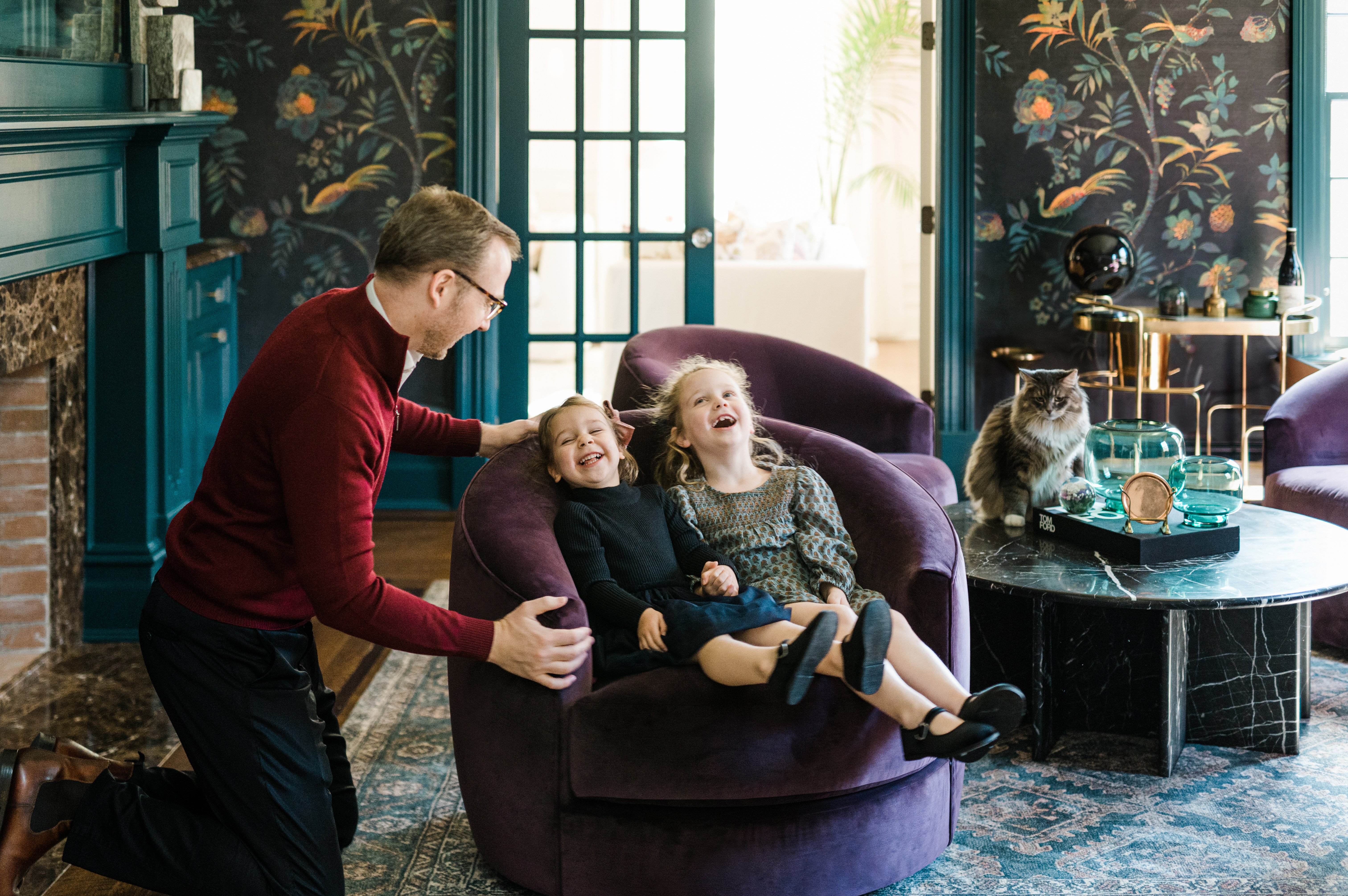 father is having fun with his two small girls swinging the chair during NYC family photography session 
